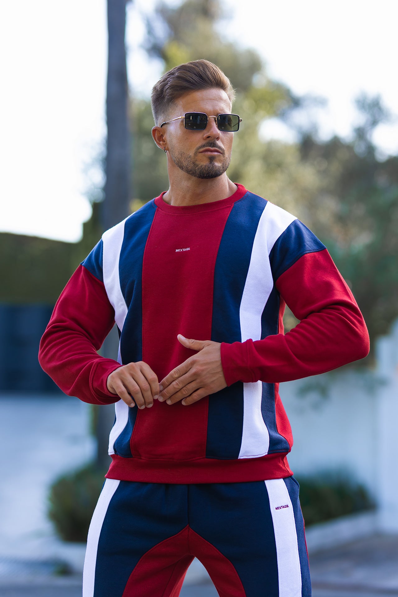 Nextage Men wearing a red, white, and blue striped sweater with matching pants outdoors.