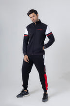 Man wearing a black and white tracksuit with red accents on a white background