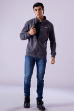 Man wearing a gray jacket, black shirt, blue jeans, and black shoes on a white background