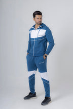 Man wearing a blue and white tracksuit on a gray background