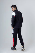 Man wearing a black and white tracksuit with red accents on a white background