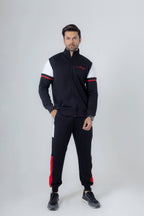 Man wearing a black and white tracksuit with red accents on a white background