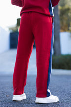Nextage Person wearing red and blue tracksuit with white shoes on a blurred outdoor background