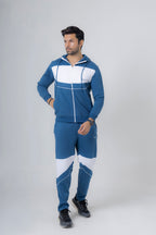 Man wearing a blue and white tracksuit on a gray background
