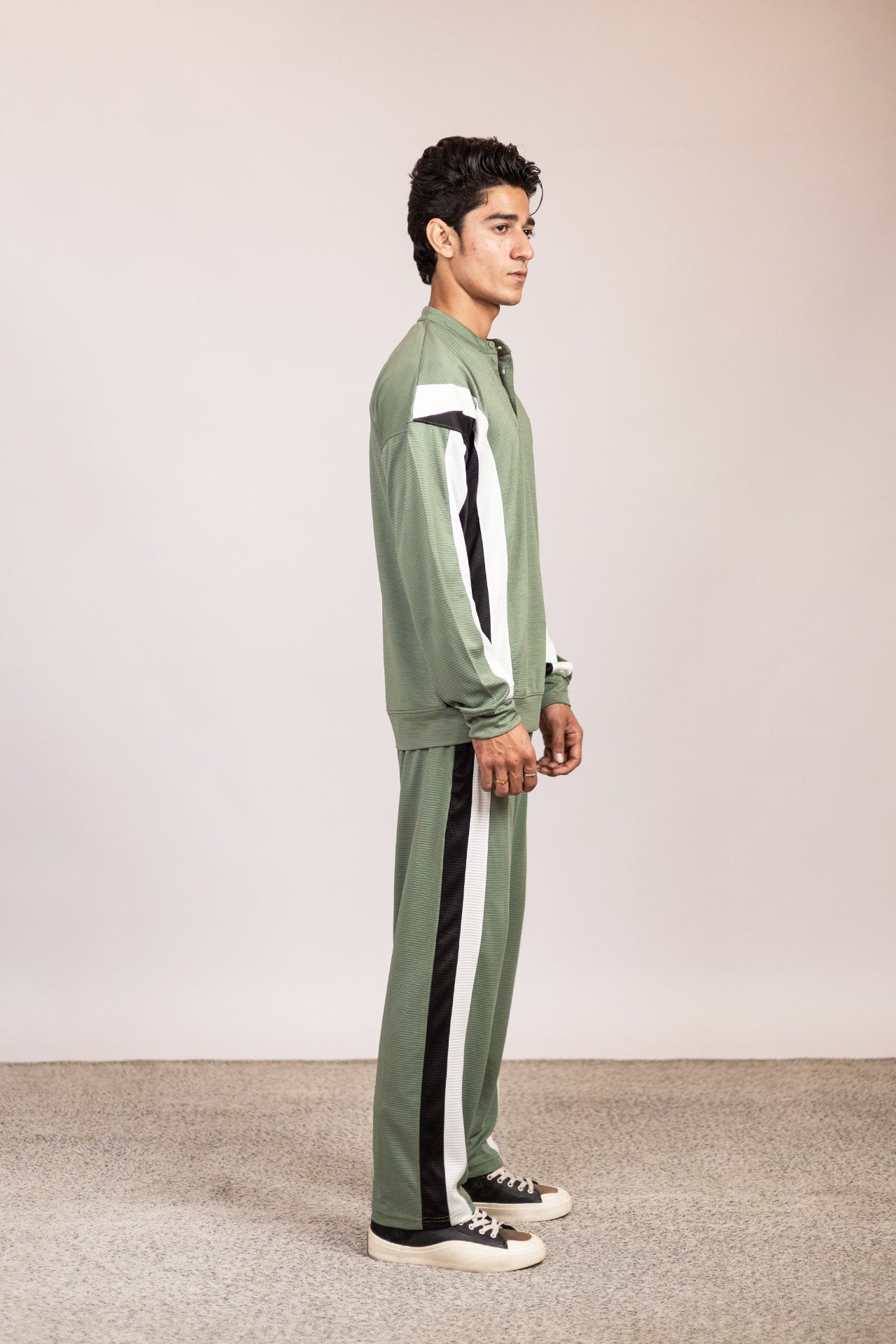 Side view of Nextage sage green men’s track suit highlighting colorblock sleeve design