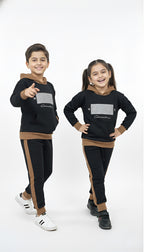 Two children wearing matching black and brown outfits on a white background