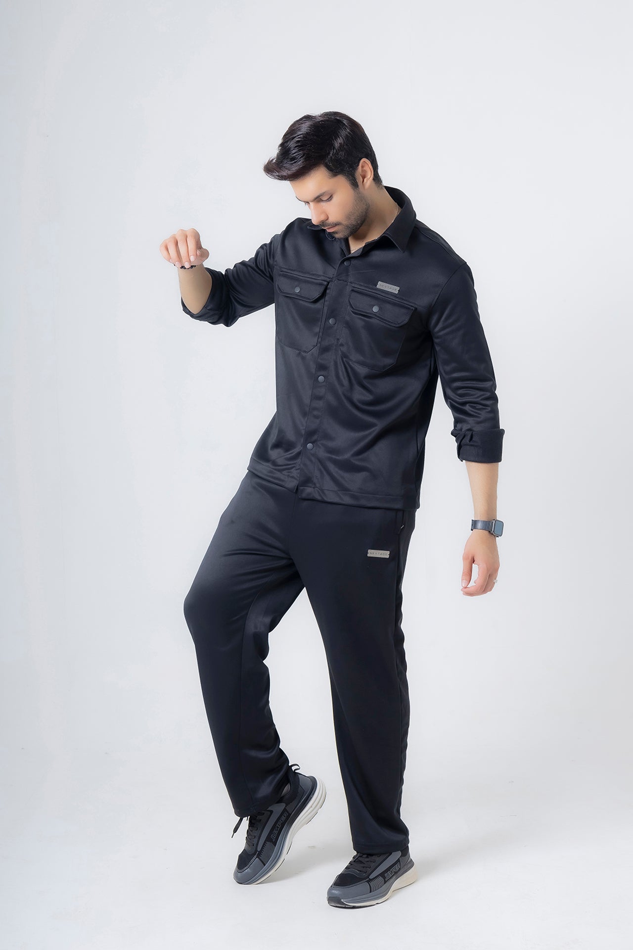 Side profile of man wearing Nextage black safari fleece tracksuit showing modern fit and design