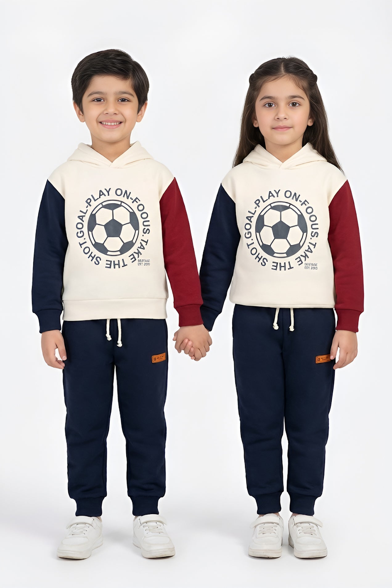 Two children wearing matching sports outfits with soccer-themed designs on a white background