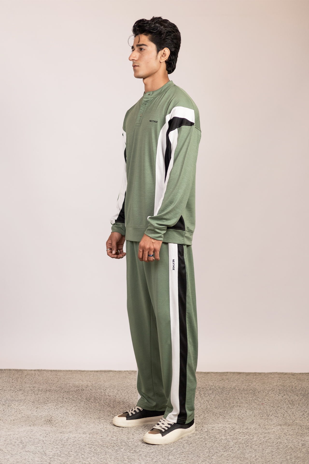 Side view of Nextage olive green men’s track suit highlighting colorblock sleeve design